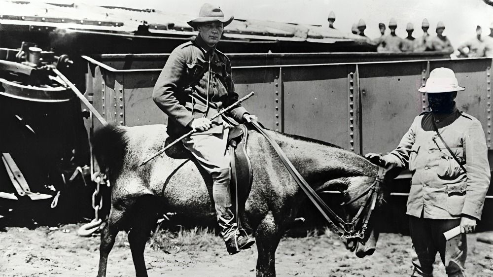 Winston Churchill was seated on a horse, with a person holding the reins beside him.