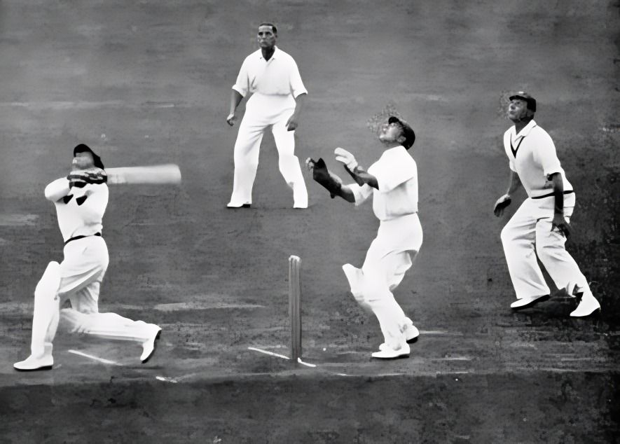 Sir Donald Bradman is standing with two other people, holding a bat.