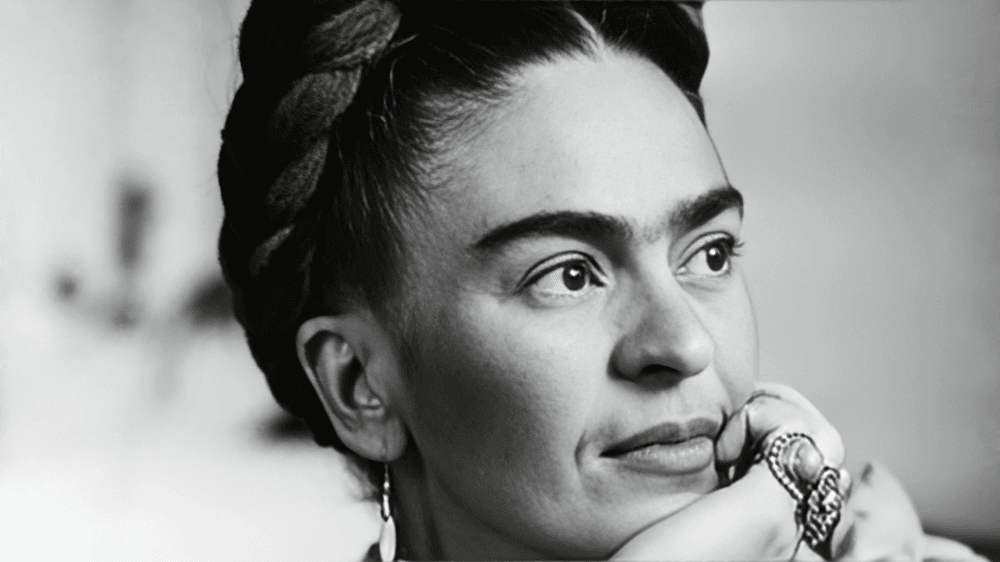 Black-and-white portrait of a woman with braided hair and jewelry.