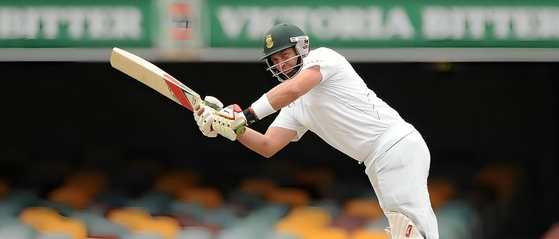 Jacques Kallis is standing in a white uniform, holding a bat in his hand.