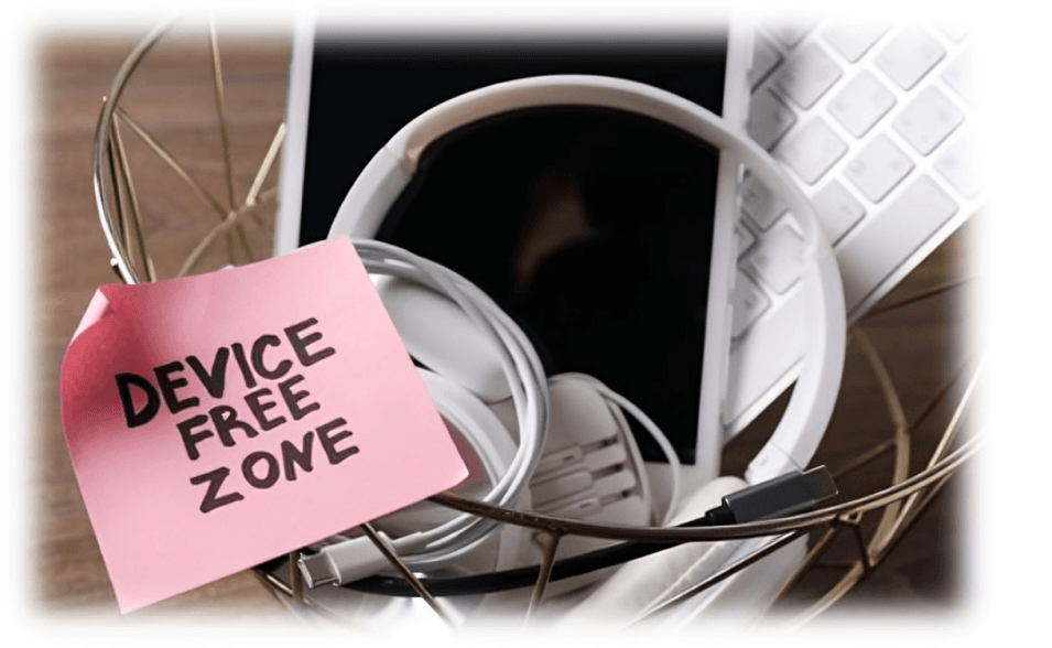 Device Free Zone sign with electronic devices in basket.