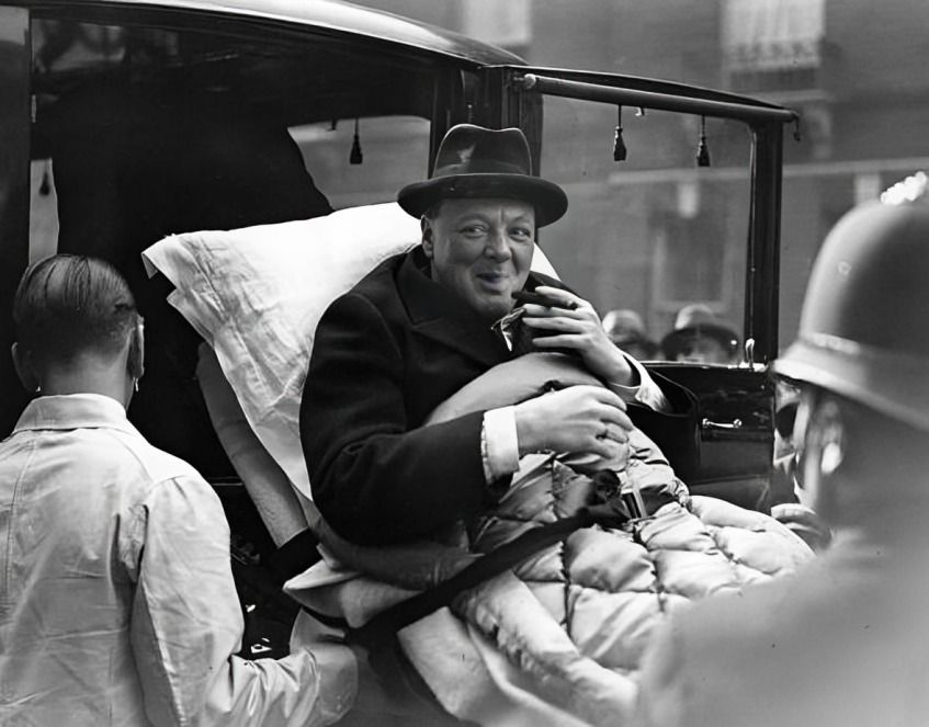 Churchill lying in a hospital bed, engaged in conversation with a doctor.