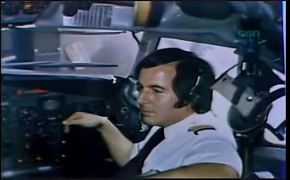 Frank Abagnale seated in an airplane, dressed in a classic pilot uniform.