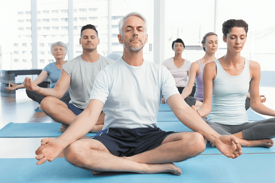 Group of diverse adults meditating peacefully in yoga class.