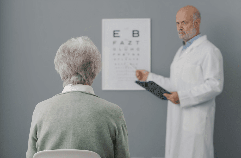 Patient facing an eye chart, doctor pointing at it.