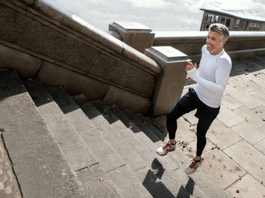 Man exercising, running up outdoor stone stairs.