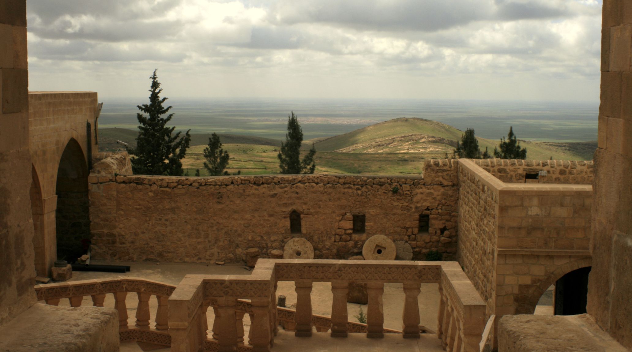 Ancient stone monastery with a view of a valley and mountains.