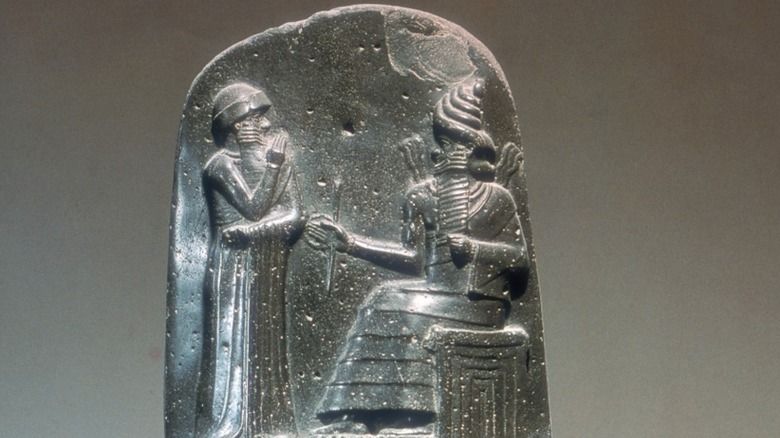Ancient stone relief of Hammurabi receiving laws from the god Shamash, symbolizing divine legal authority.