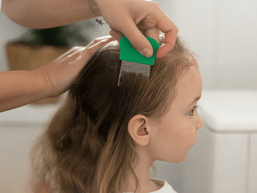A person using a lice comb on a child's hair.