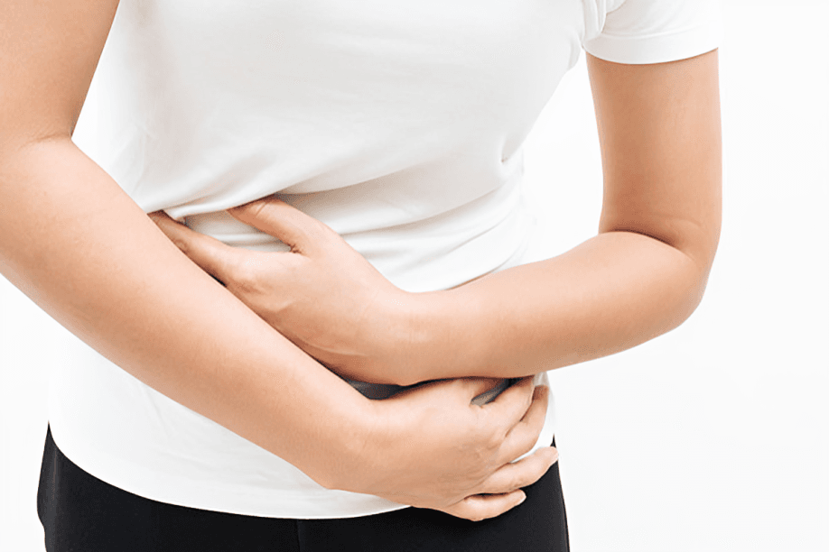 A person clutching their abdomen, appearing to experience stomach pain.