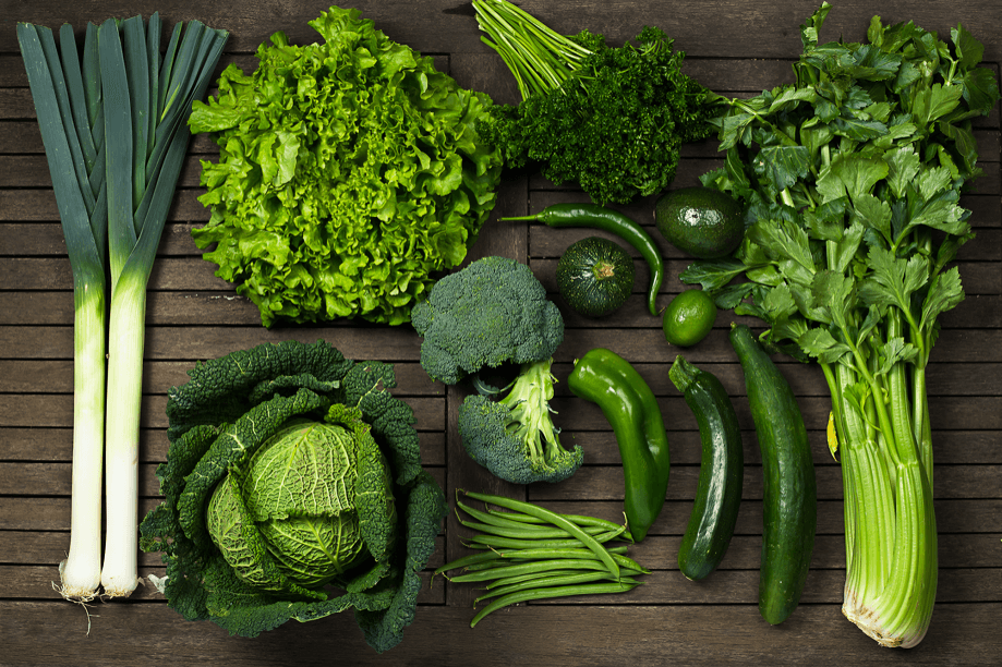 A collection of fresh, green vegetables on wood.