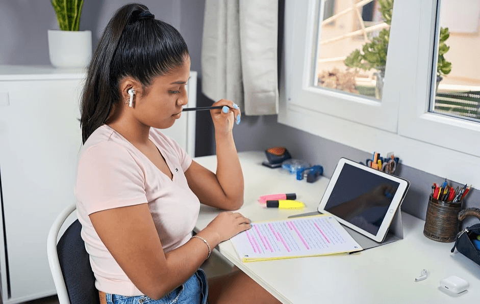 Young woman concentrating on studying with a tablet.