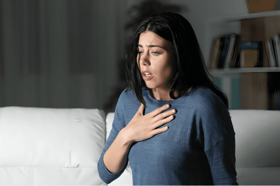 Distressed woman with hand on chest, possibly experiencing anxiety.