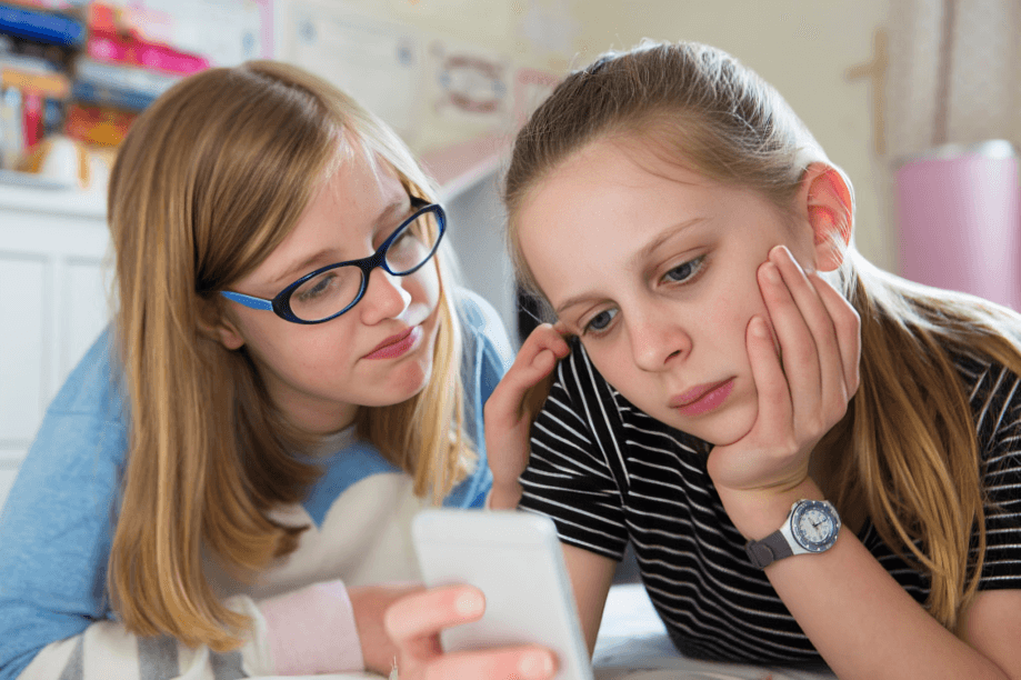Two young people looking at a smartphone with concern.