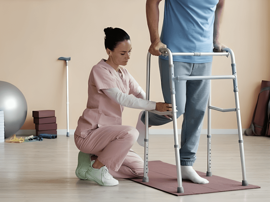 A rherapist helping a man with physical therapy using a walker.