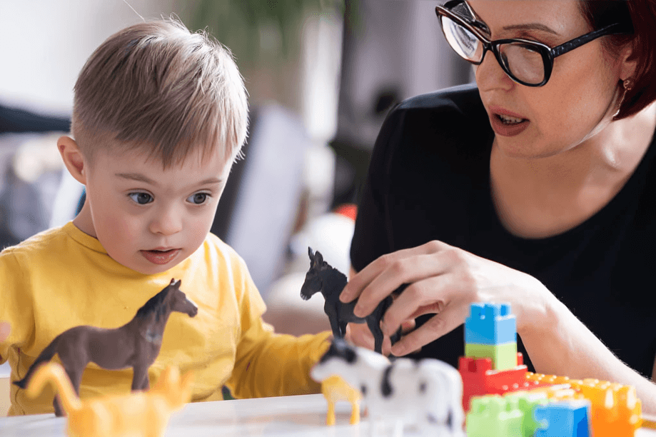Woman and child playing with animal toys.