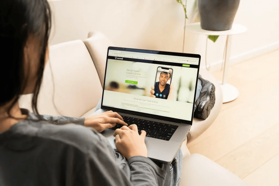 Person video chatting with therapist on a laptop.