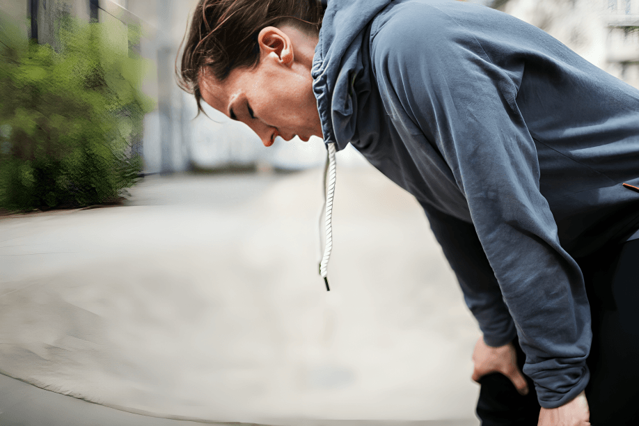 A woman in workout clothes appears to be experiencing shortness of breath.
