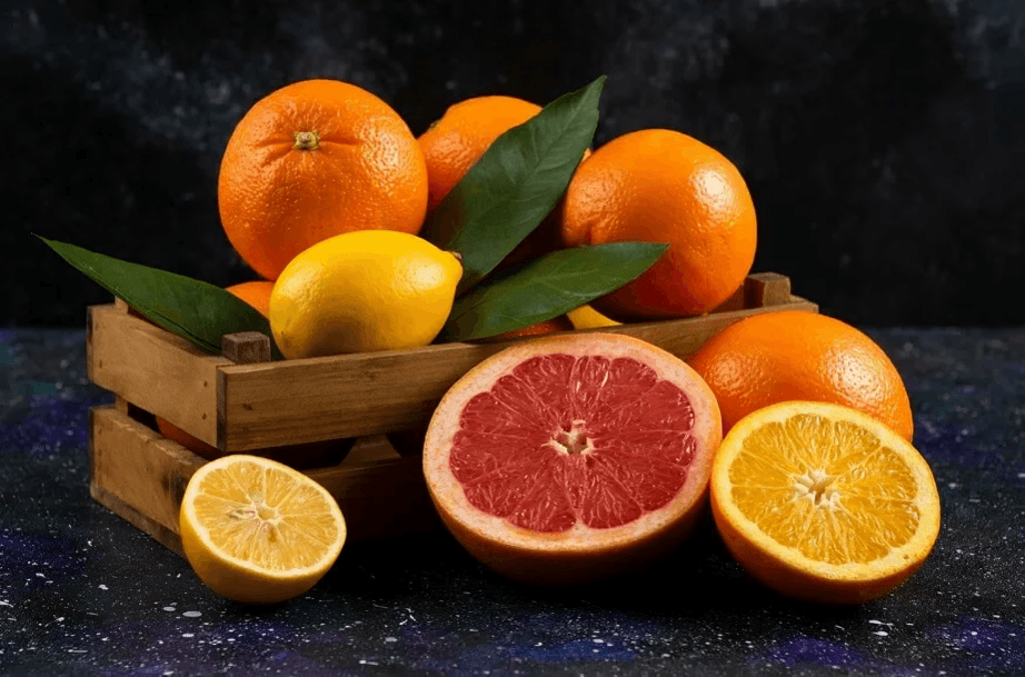 A crate of oranges, grapefruits, and lemons.