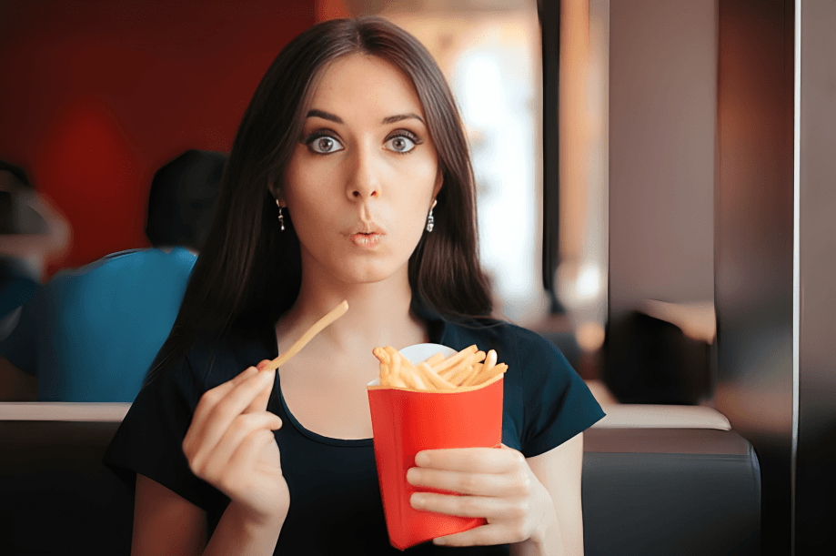 Woman eating McDonald's French fries with a surprised expression.