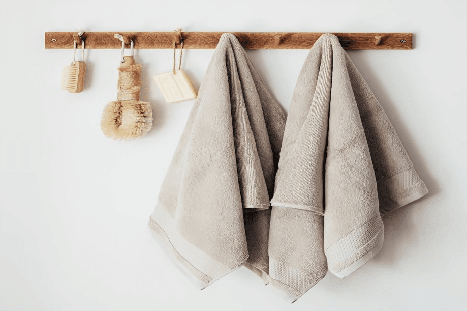 Towels and bath brushes hanging on a wooden rack.