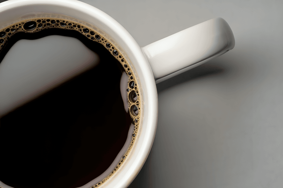 A close-up, top-down view of black coffee in a mug.