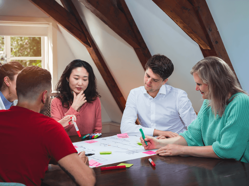 A diverse group collaborating on a project at a table.