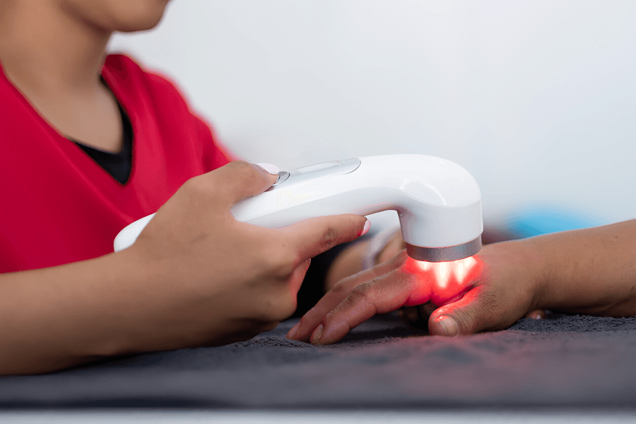 Close-up of laser therapy device on a hand.