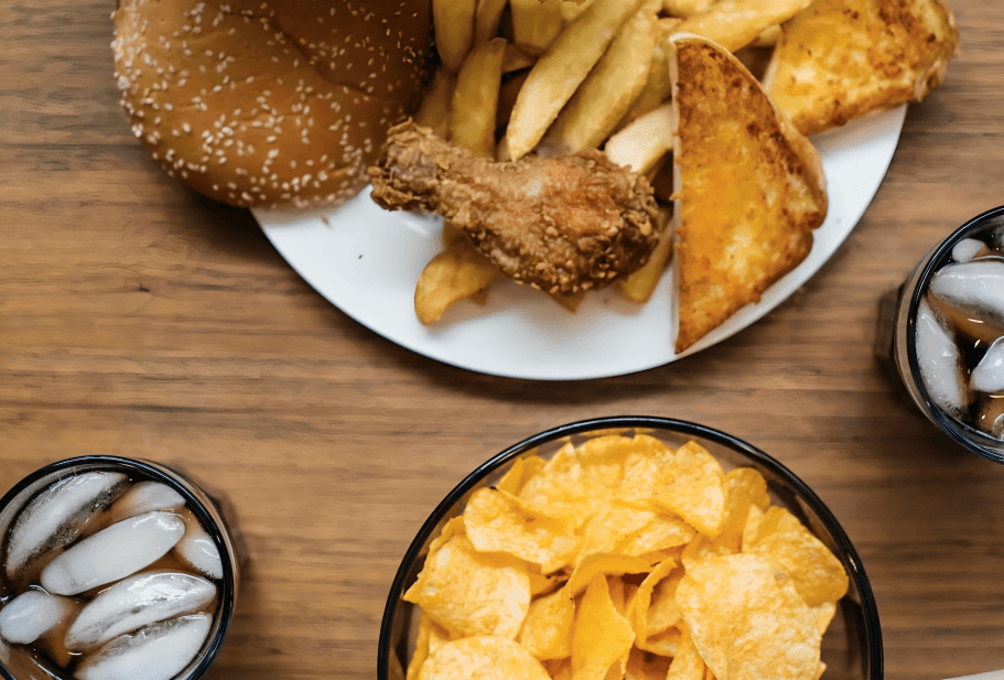 Fast food: fried chicken, chips, and soda drinks.
