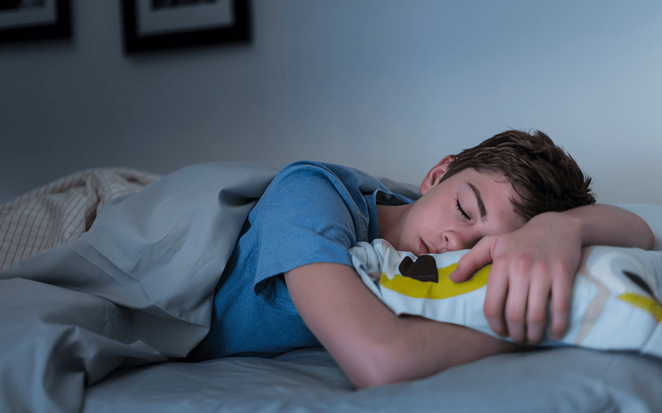 A young man peacefully sleeping on his side.