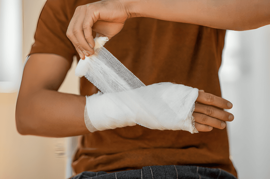 Person with brown shirt bandaging their injured wrist.