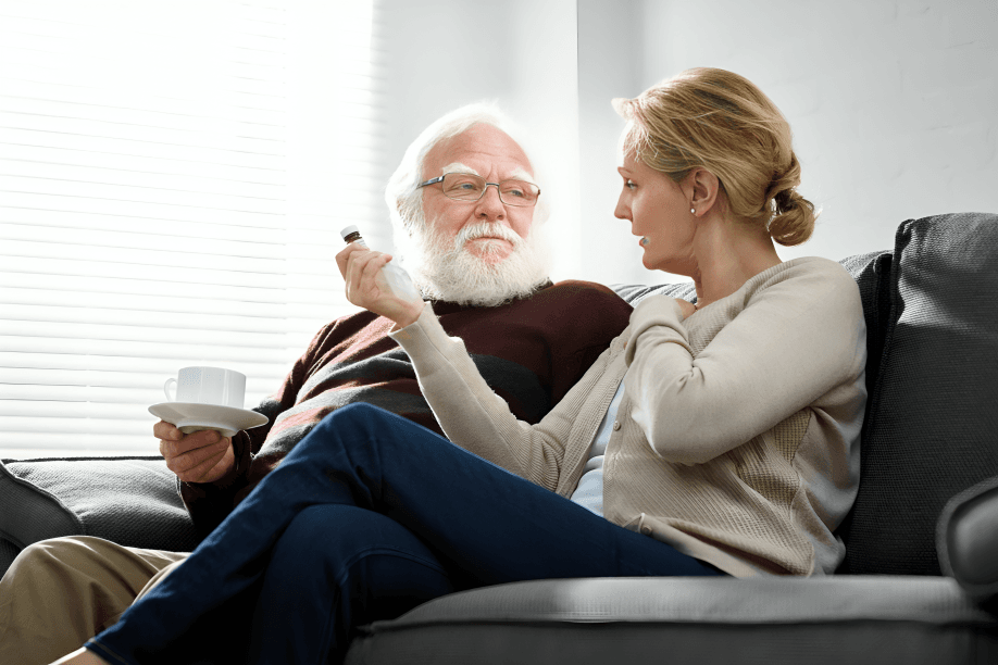 Senior couple discussing medication on a couch.