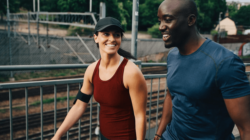 A smiling couple walking together after a run.