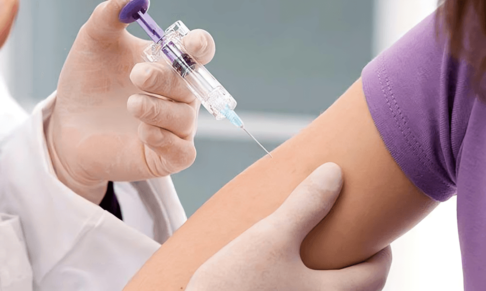 The doctor gives an injection to the person's arm.