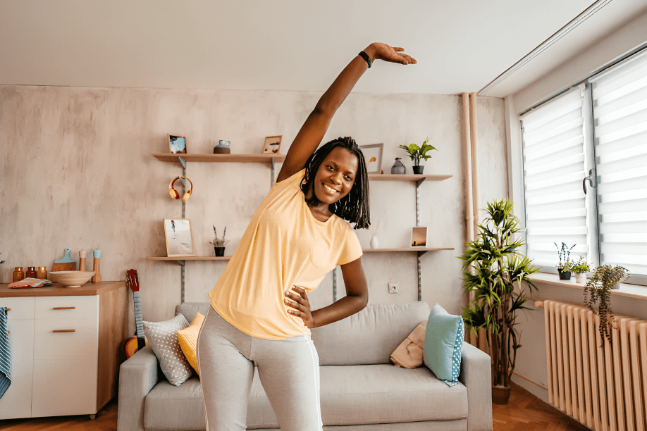 Happy woman stretching in a bright, cozy living room.