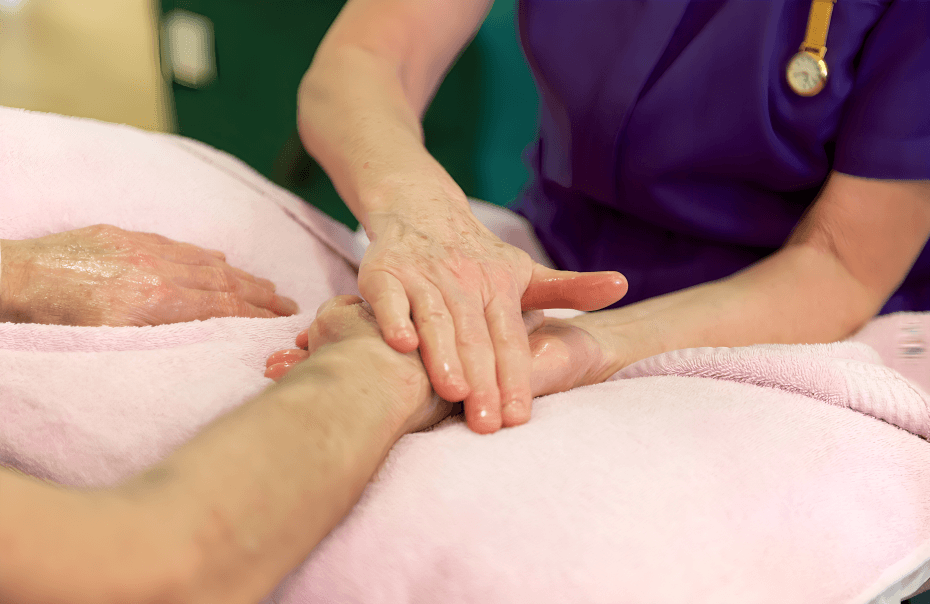 A nurse performing a hand massage on a patient.