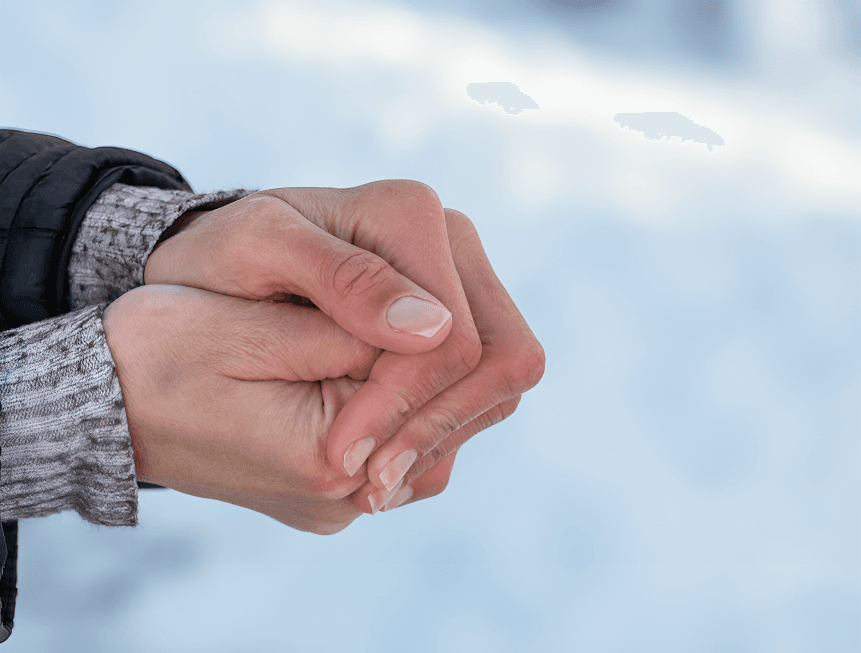 Person's clasped, reddish hands indicating cold or Raynaud's.