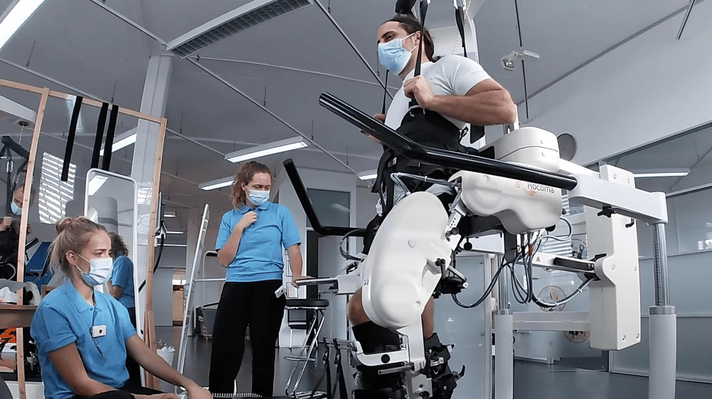Patient undergoing gait training with therapists.