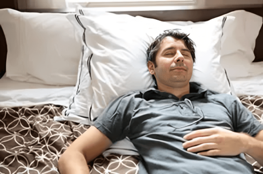 A man sleeping peacefully on a bed.