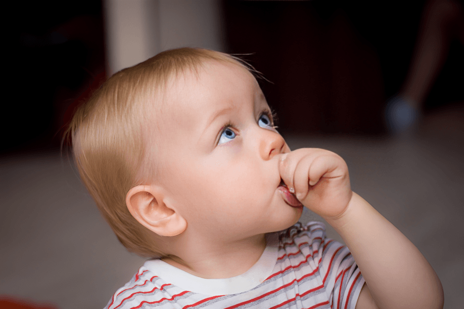 Close-up of a baby with blue eyes looking up.