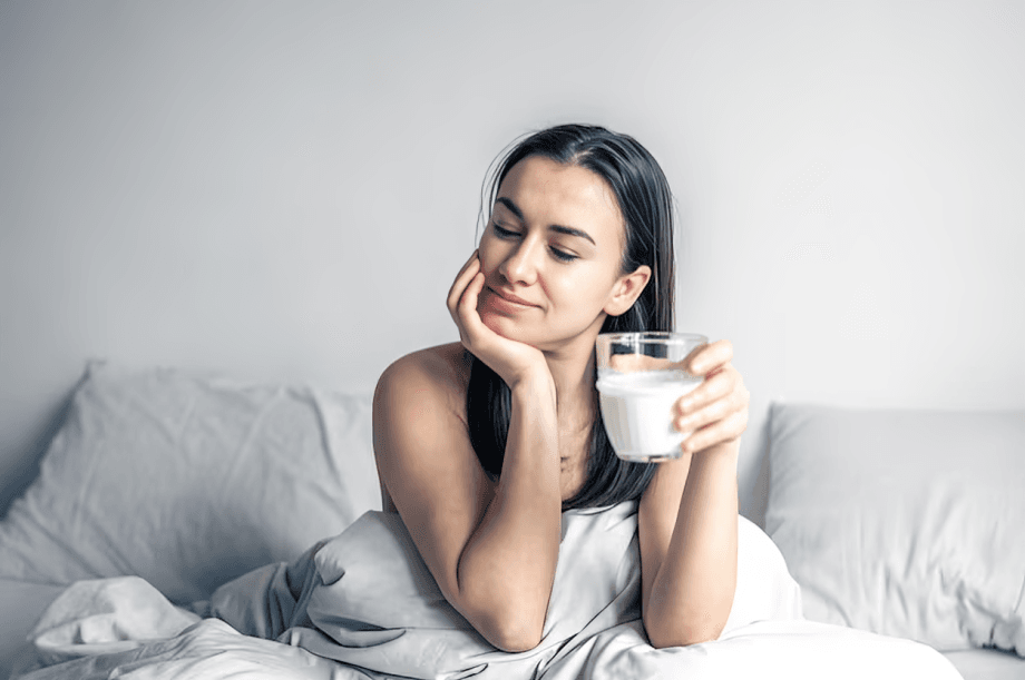 A glass of water sits on a bedside table.