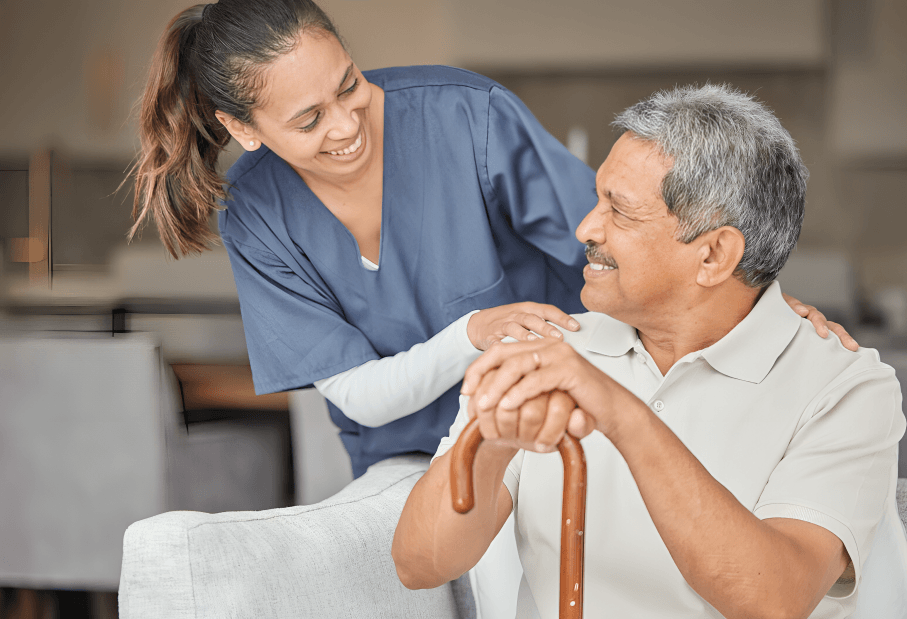 A caring nurse smiling with a senior male patient.