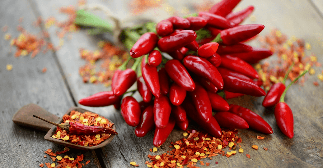 A bunch of red chili peppers with flakes.