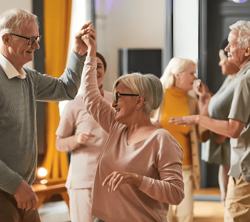 Happy seniors dancing and socializing at a party.