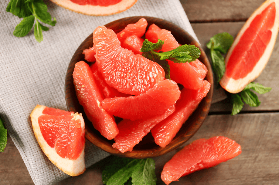 Peeled grapefruit segments in a bowl with mint.