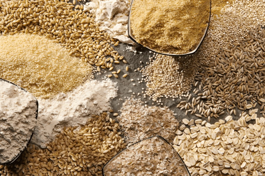 Assorted grains and flours on a textured surface.