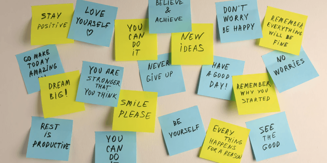 Post-it notes with motivational messages on a wall.
