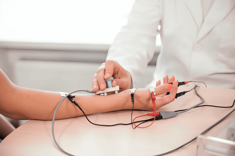 Nerve conduction study being performed on a patient's arm.