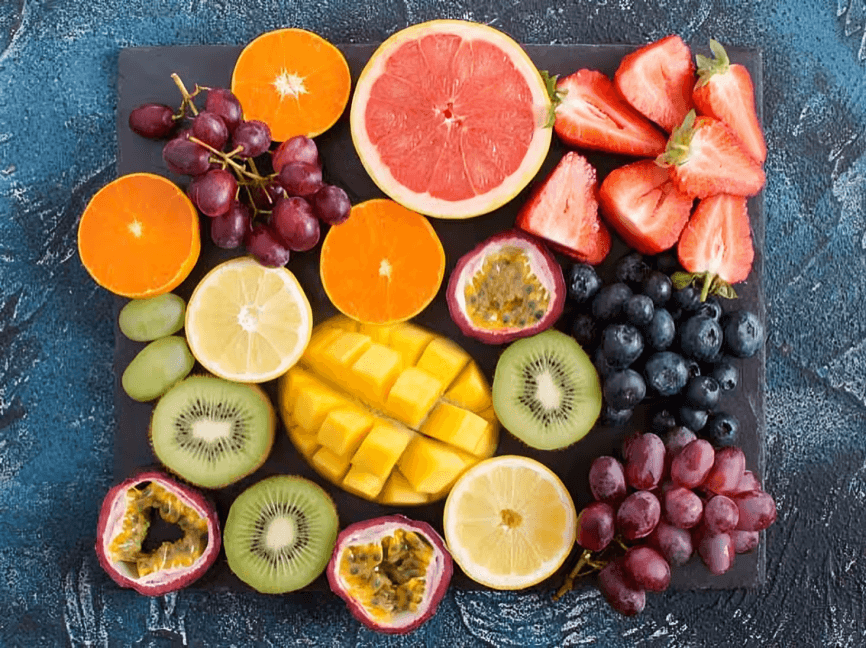 Colorful assortment of fresh, sliced fruits on a board.