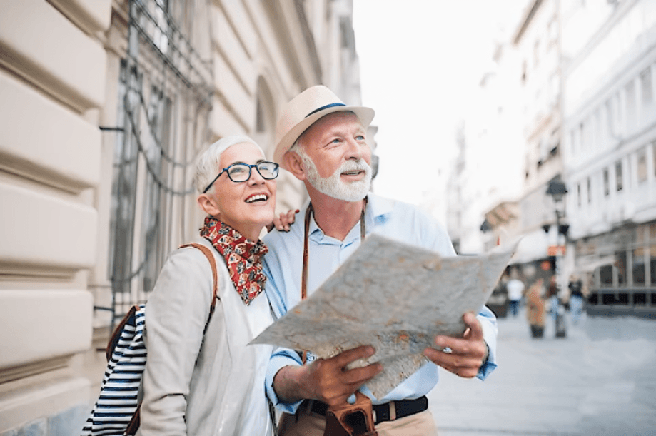 A happy senior couple exploring the city with a map.